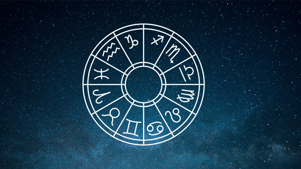 A white zodiac wheel with twelve astrological signs is centered on a dark blue starry night sky background, perfect for anyone interested in astrology or inspired dressing ideas for Valentine’s Day.